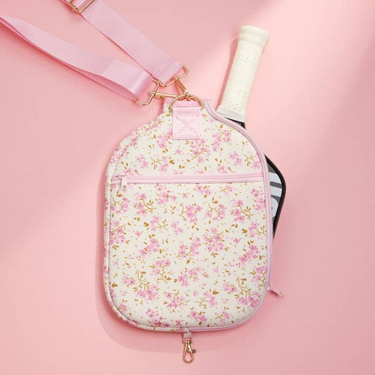 Floral-patterned paddle case with pink strap on a pink background