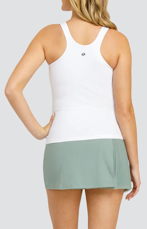 A woman wearing a white sleeveless tank top and a green skirt.