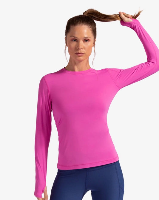 A woman wearing a long sleeve pink sun shirt with a left shoulder pocket, displaying the front view of the shirt.