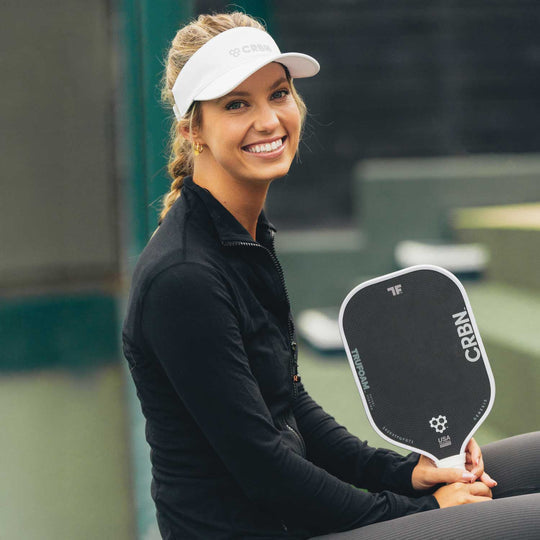 A black and green CRBN Tru Foam Genesis Hybrid 14mm paddle with a foam core, alongside a black carrying case. The paddle features geometric patterns and branding details in white and green colors.