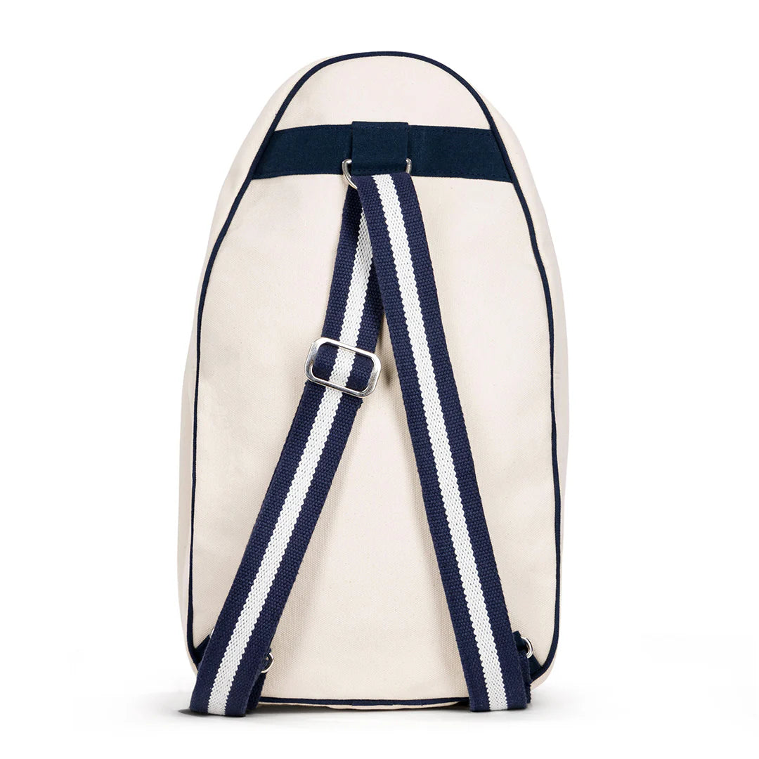 A canvas pickleball sling bag with adjustable strap, featuring a natural color on the bottom and navy color on the top, with an exterior front mesh pocket and a zippered closure.
