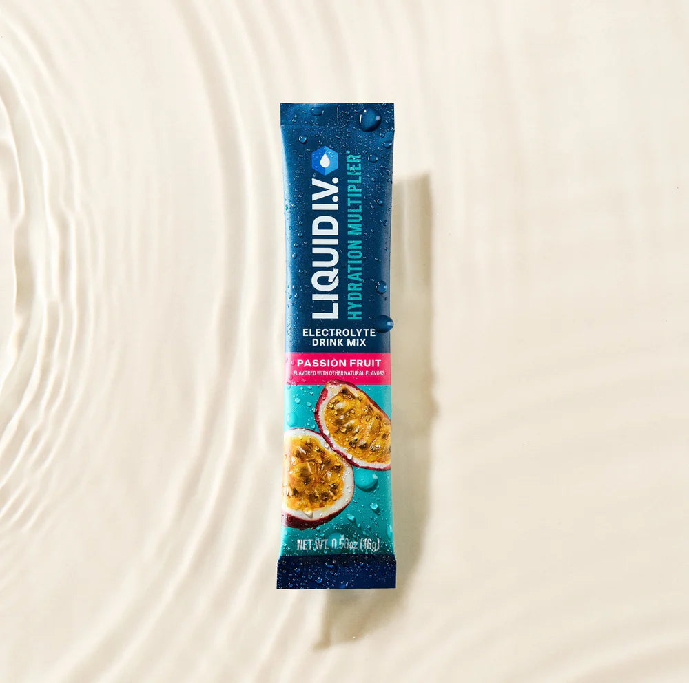 A stick of Liquid IV Hydration Multiplier in Passion Fruit flavor, with a background that is out of focus and has a blue color texture.