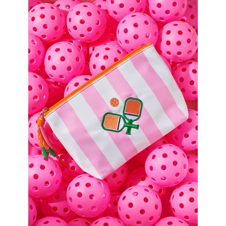 Pink striped pouch with pickleball design on a bed of pink pickleballs