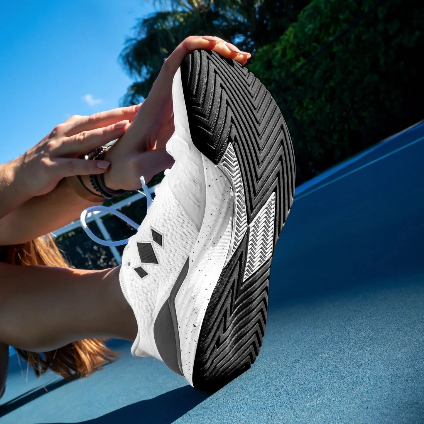 White athletic shoe with black accents on a pickleball court