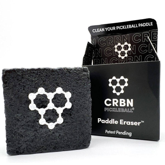 A black CRBN Pickleball Paddle Eraser next to its packaging, which is also black with the product name and branding visible.
