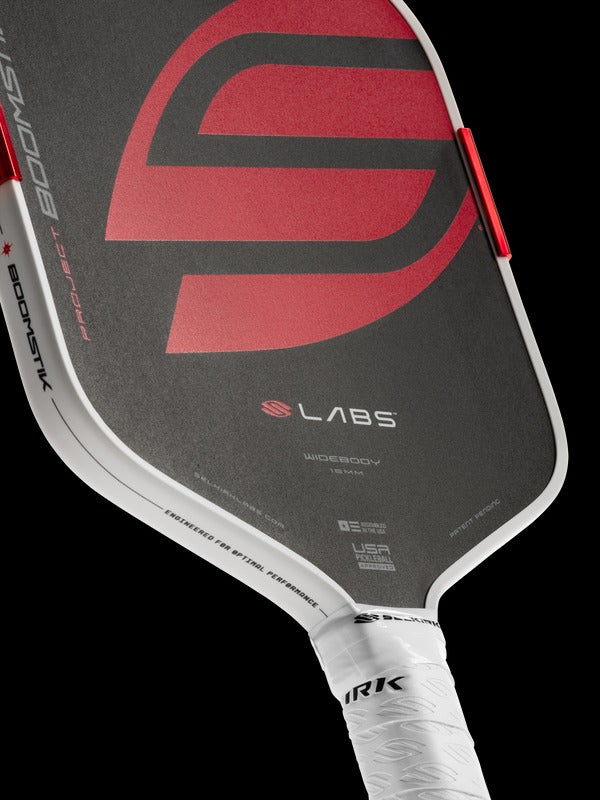 Close-up of a pickleball paddle with visible branding on a black background