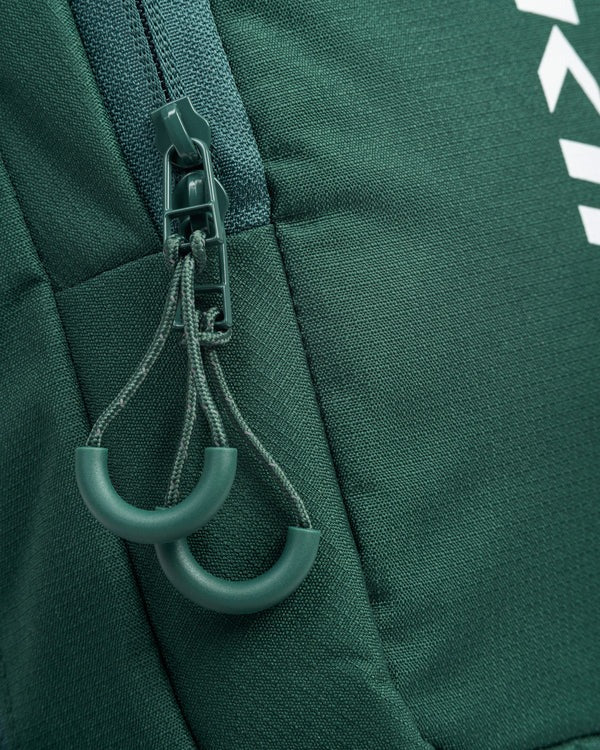 Close-up of a green zipper with a carabiner on a green fabric background