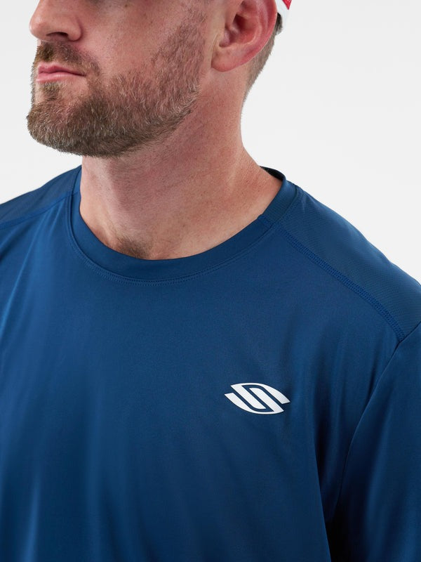 Man wearing a blue shirt with a logo on a white background
