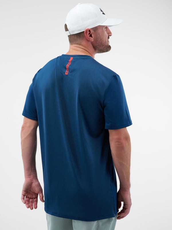 Man wearing a blue t-shirt with a red logo on the back against a white background
