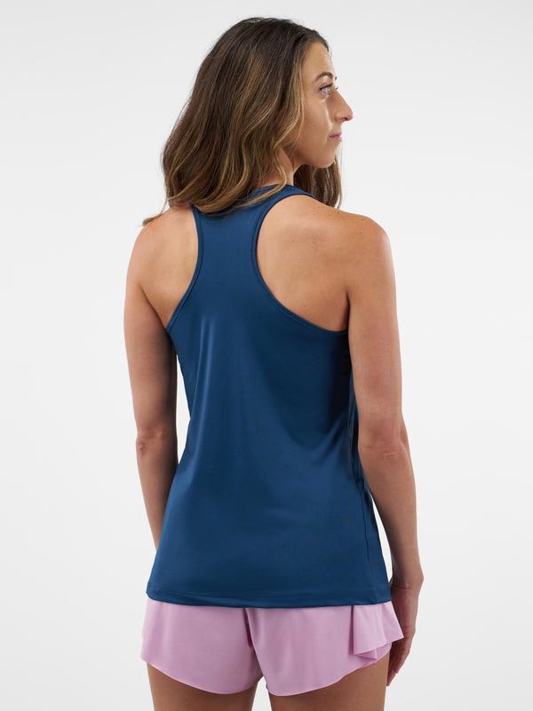 Woman wearing a blue tank top and pink shorts on a white background