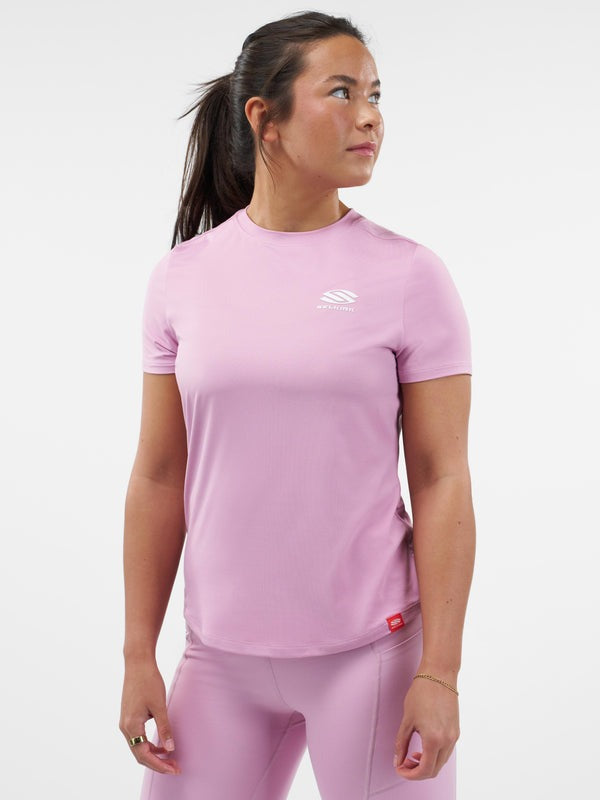Woman wearing a pink athletic outfit with a logo on a white background