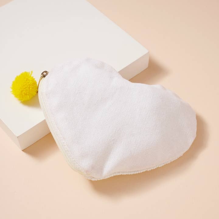 Purse bag with a yellow pom-pom on a beige background
