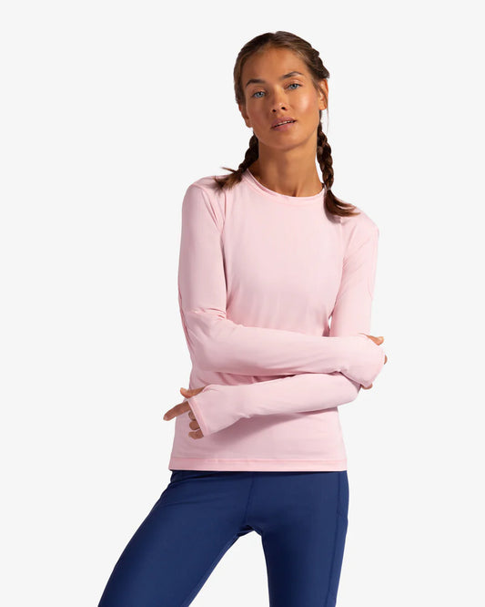 A woman wearing a long sleeve pink sun shirt with a left shoulder pocket, displaying the front view of the shirt.