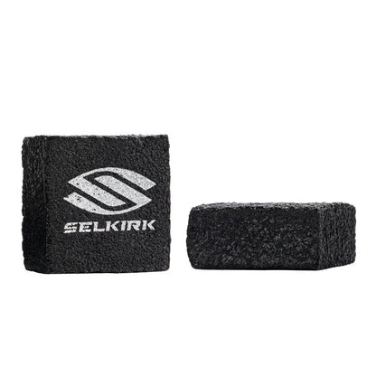Two black cleaning blocks with a white logo on a white background