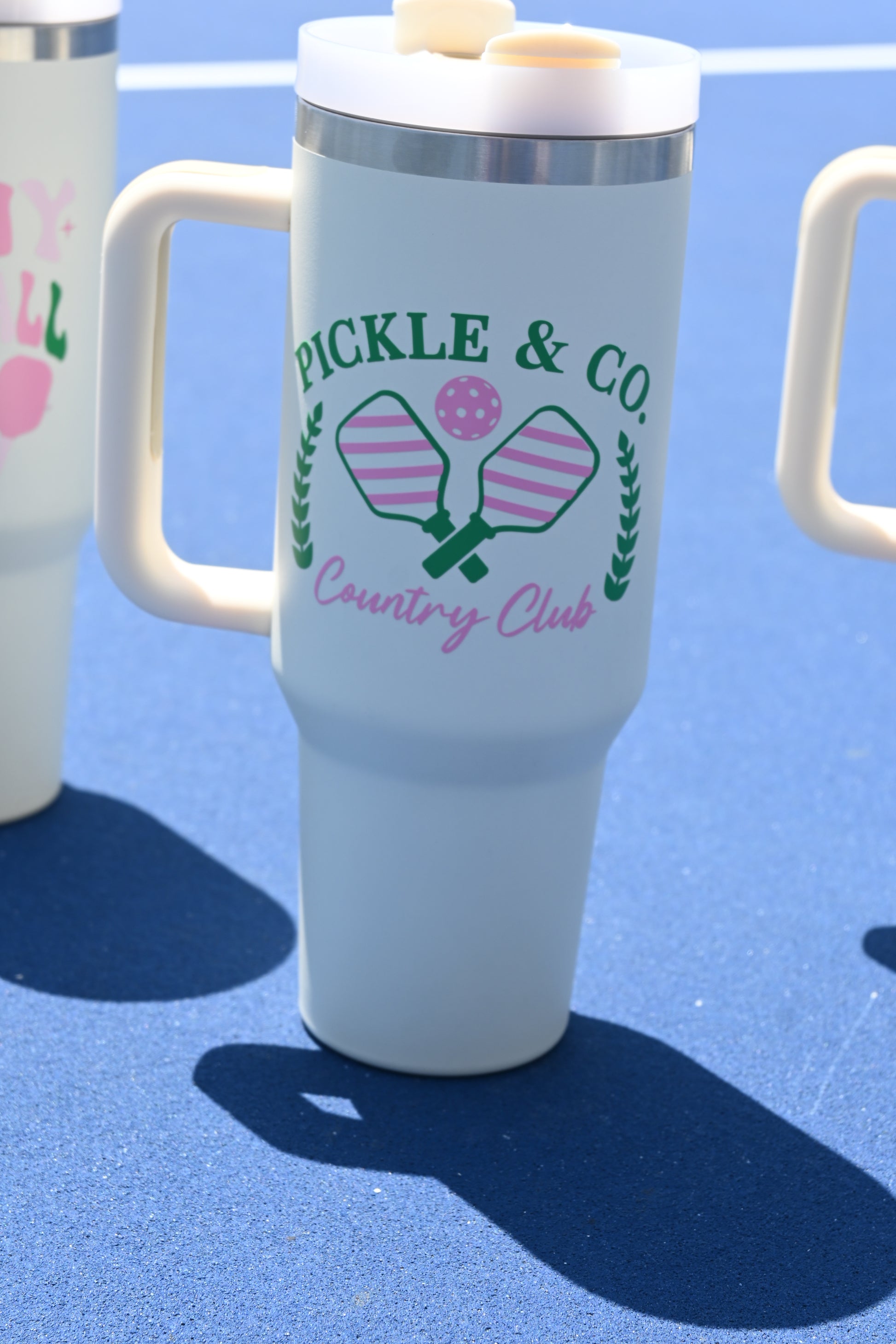 Clear bottle with green text and pink design on a blue background