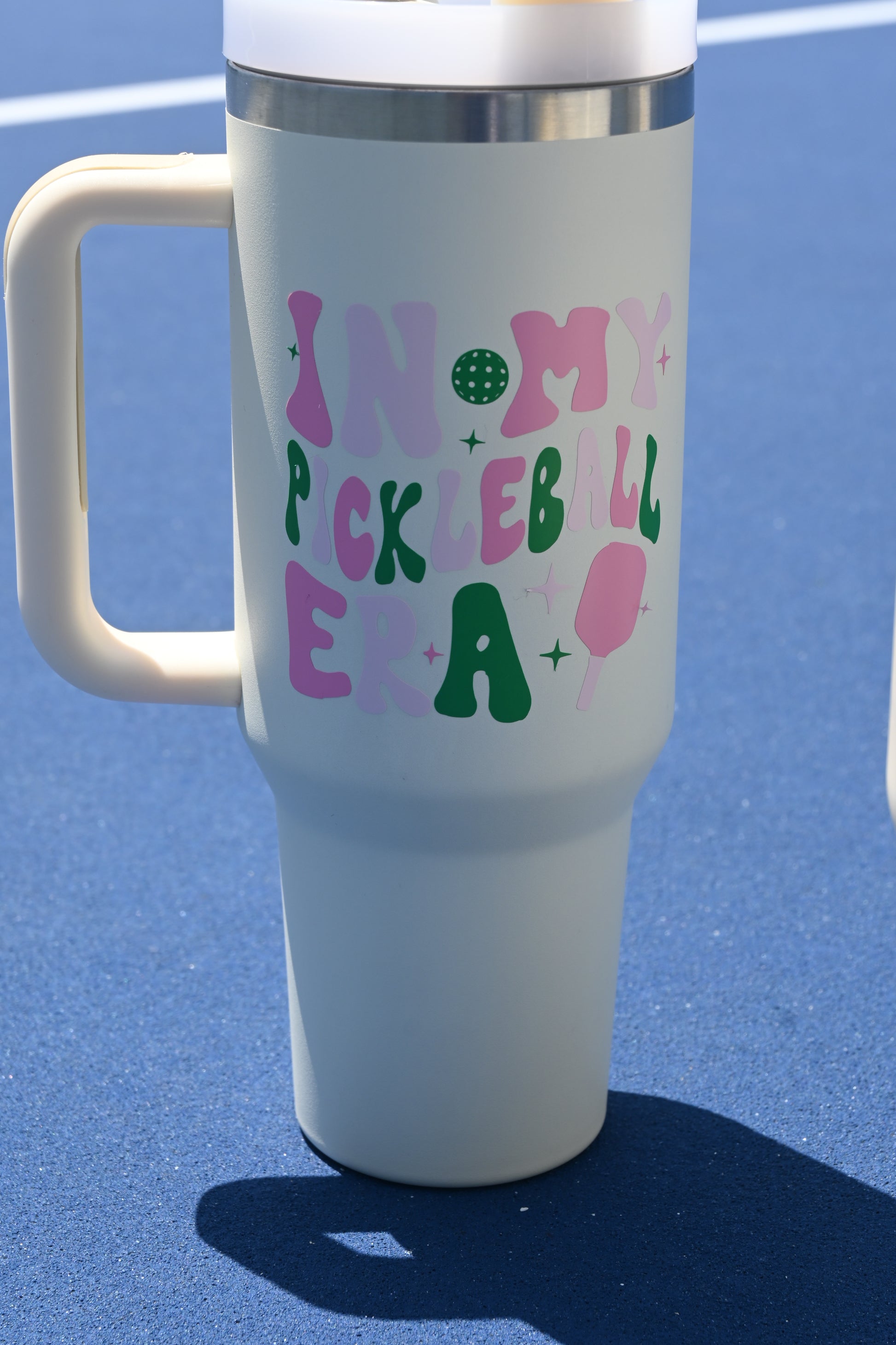 White tumbler with colorful text on a blue background