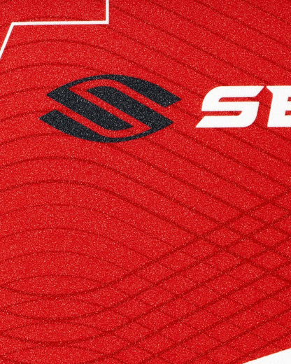 Close-up of a red textured surface with a black and white logo.