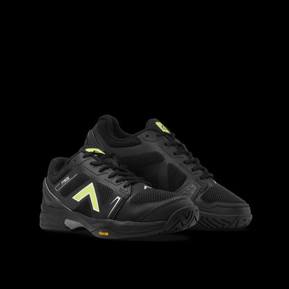 Black athletic shoes with yellow accents on a black background
