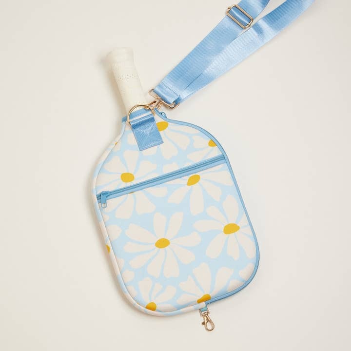 Paddle bag with daisy pattern and blue strap on a light background