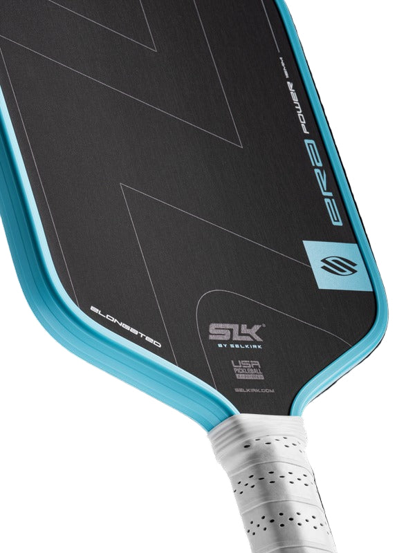 Close-up of a pickleball paddle with branding on a white background