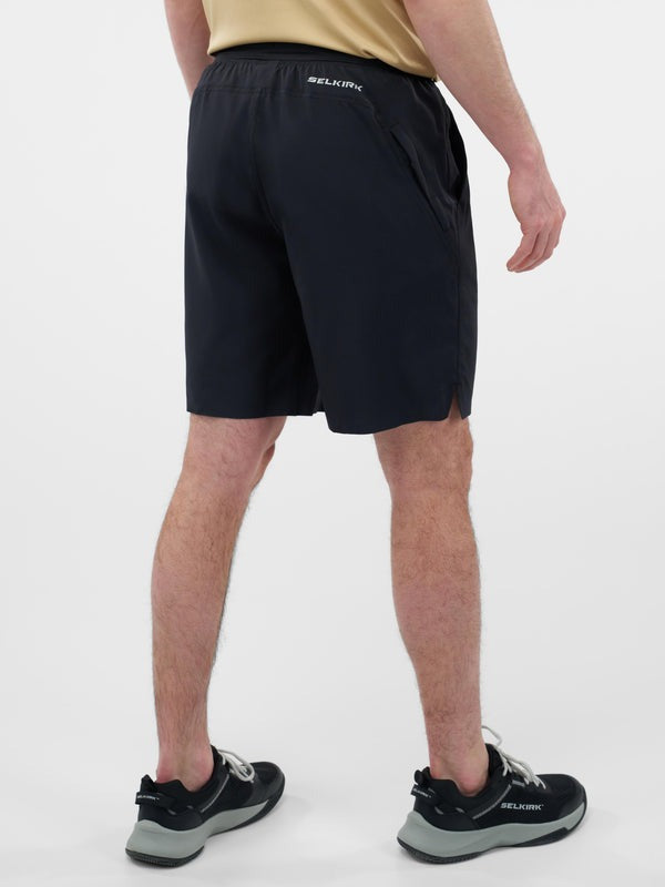Person wearing black shorts with a brand logo on a white background