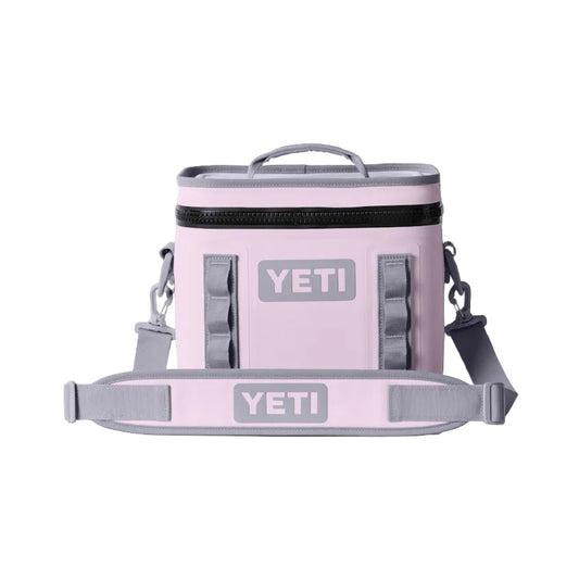 Pink YETI cooler bag with gray straps on a black background